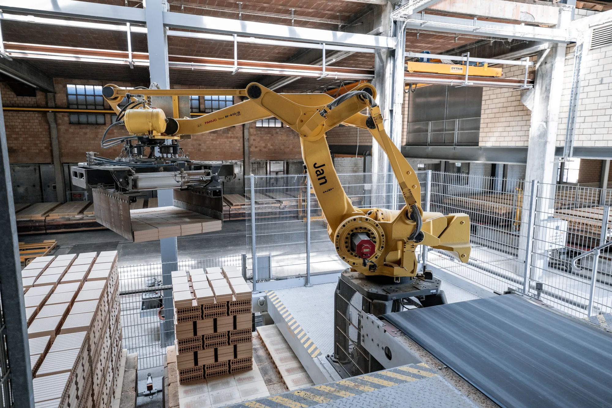 Roboterarm beim Palettieren von Backsteinen