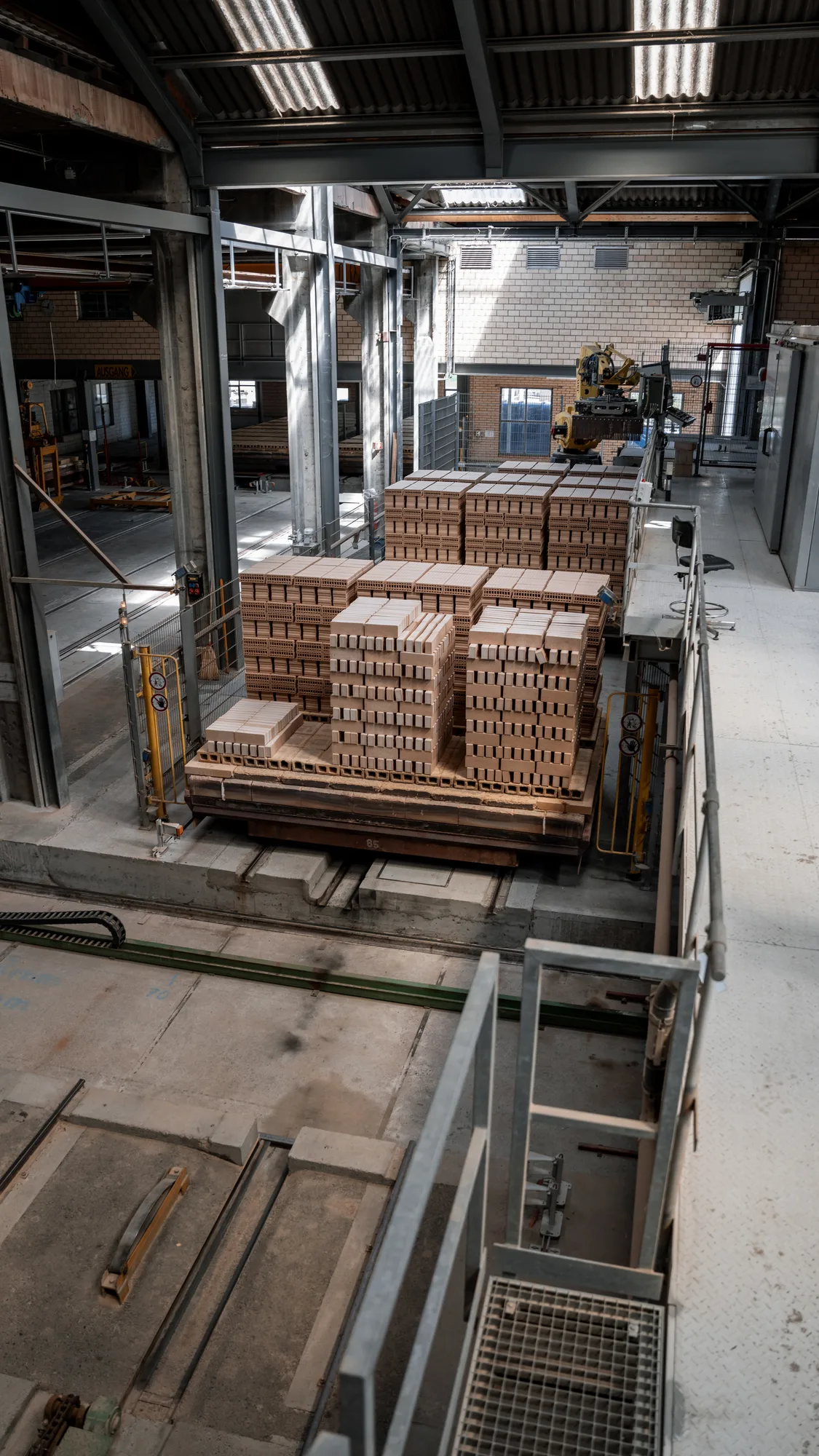 Produktionshalle mit Robotik und Backstein-Paletten